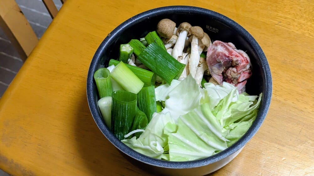アイリスオーヤマの電気圧力鍋の内鍋に肉と野菜が詰め込んである画像