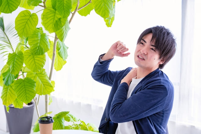 肩を回すビジネスパーソンの画像