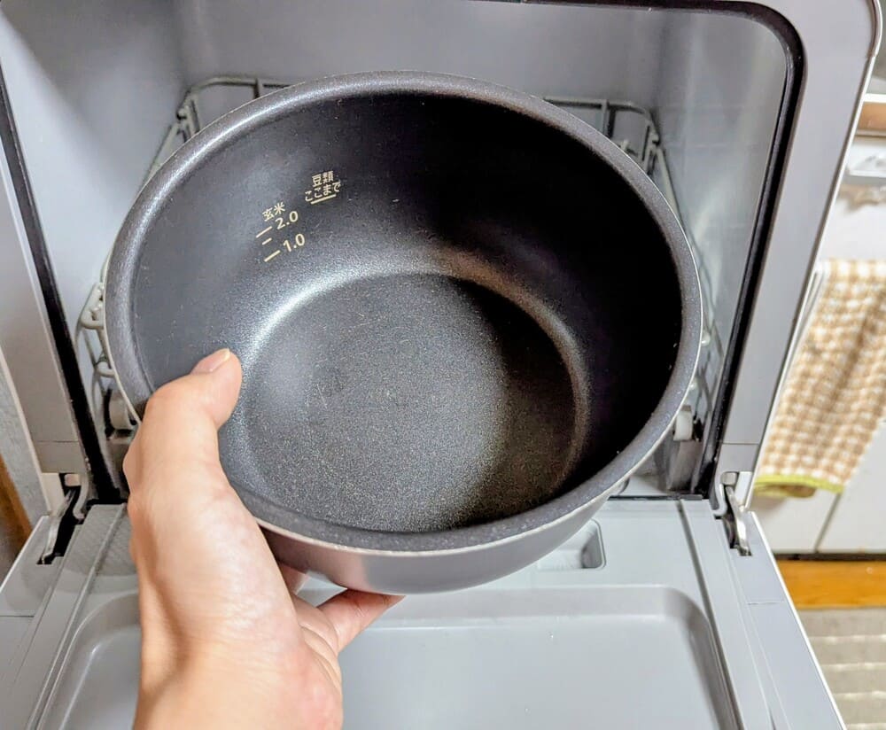 アイリスオーヤマの電気圧力鍋の内鍋を食洗機の前で手に持っている画像