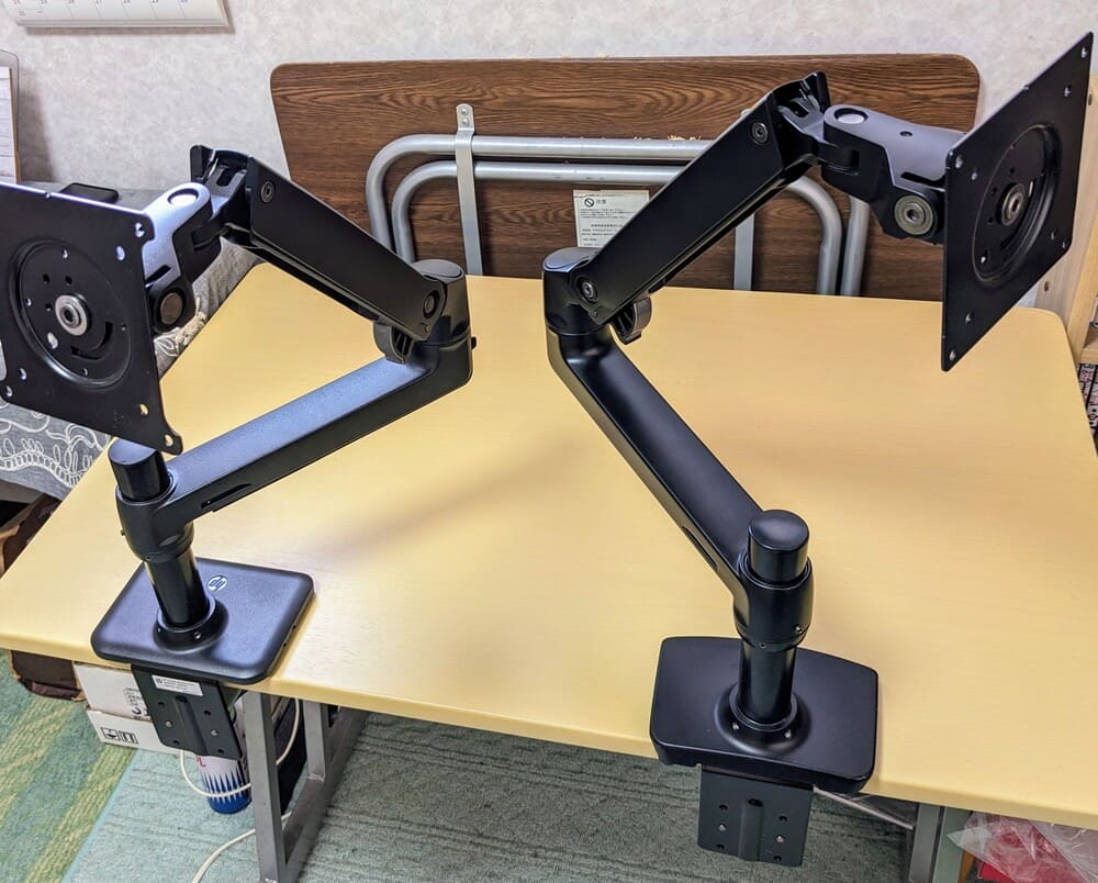 2つのエルゴトロンLXのOEM商品をテーブルに取り付けている画像