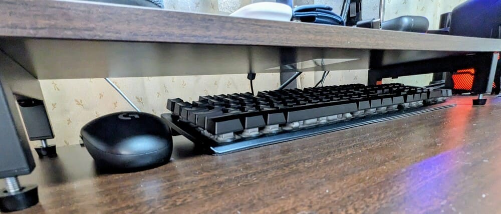デスクシェルフの下にキーボードとマウスが収納されている画像