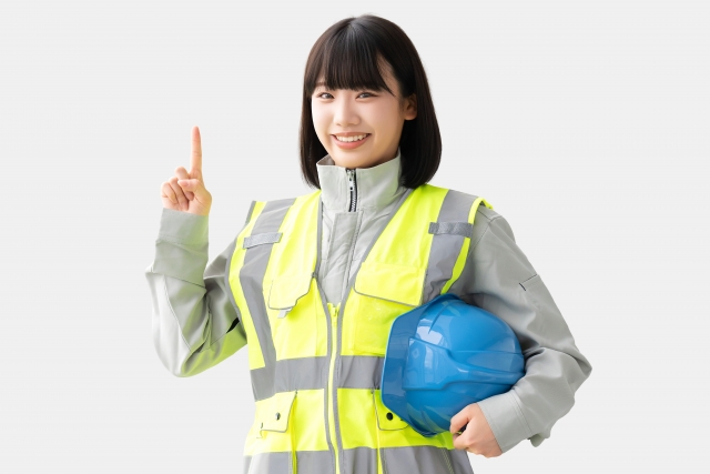 反射ベストと作業服を着た笑顔の女性