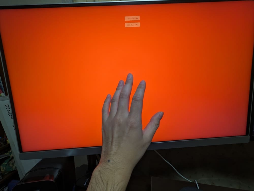 INNOCN 27M2Vのオレンジ色の画面に手をかざしている画像