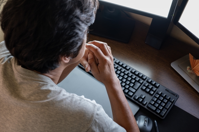 モニターを見つめる男性の画像