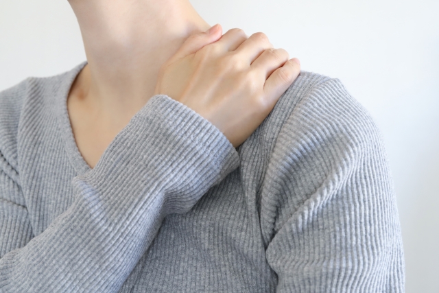 右手で左肩を抑えている人の画像
