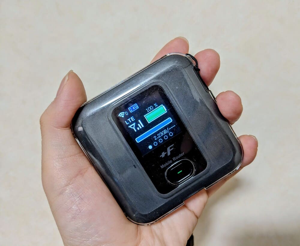 手にdinomoWiFiのルーターを持っている画像